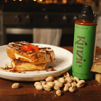 Stack of pastries with a bottle of Kivzie chocolate sauce on a wooden table. Kinzie BBQ Sauce Uses