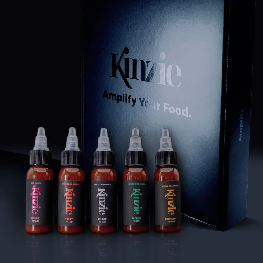 Five 1 oz bottles of Kinzie BBQ sauces in a gift box, featuring sweet, spicy, ghost, bold, and espresso flavors.