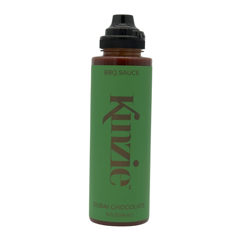 Green bottle of Kinzie Dubai Chocolate BBQ Sauce on a white background